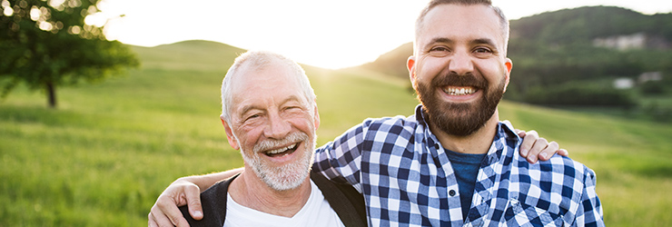 happy father and son smiling in a field