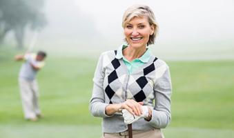 woman with crowns smiling at a golf course