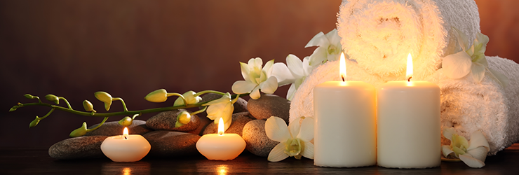 Lit candles, towels and rocks displayed in massage room as part of the bliss package