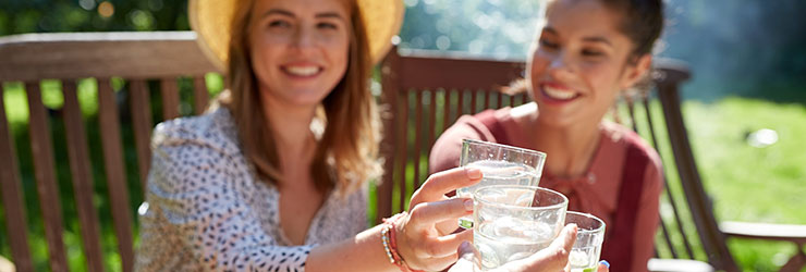 group of women smiling while drinking a glass of cold water