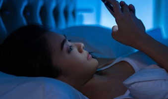 women on her phone about to go to sleep